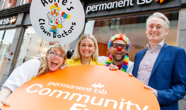 Three of our permanent tsb staff outside of our Grafto Street Branch with a street performer